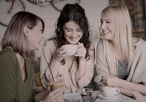 Женщины общаются в кафе